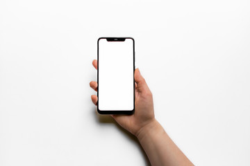 Black mobile phone with a white screen on a white background in a hand, with the clipping path. Photo in good quality.