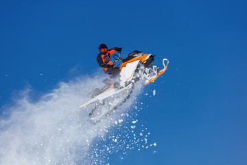 Snowmobile Jump. Extreme Snowmobile Ride & Racing. a bright suit and a snow motorcycle. Winter Recreation. high resolution and photo quality