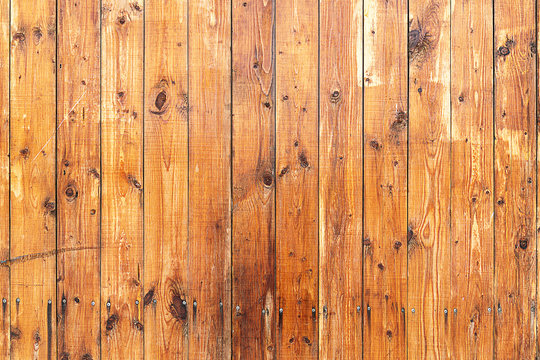 Texture. The surface of red painted wooden boards. Old boards and paint half-erased in the sun. Boards are screwed © Sergey