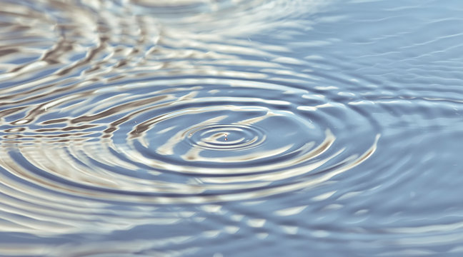 Round droplets of water over the circles on the water. Ripples on sea texture. Closeup water rings