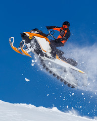 snowmobile rider jumping through snow. RIDER MAN WITH HELMET JUMPING WITH SNOWMOBILE BETWEEN SKY ON...