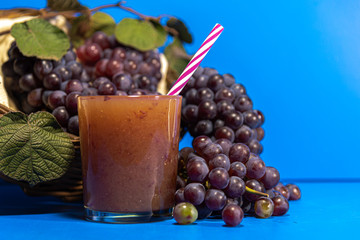 Niagara grape juice and bunches (Vitis labrusca 'Niagara') on blue background