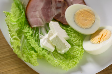 Tofu cheese on a green salad with half an egg and bacon. Healthy eating for all ages. Proper separate nutrition.