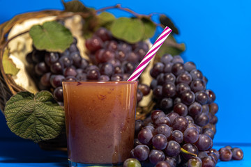 Niagara grape juice and bunches (Vitis labrusca 'Niagara') on blue background