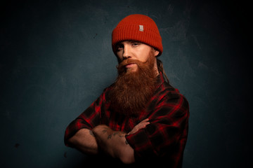 Red bearded man with orange hat and plaid shirt on cyan background