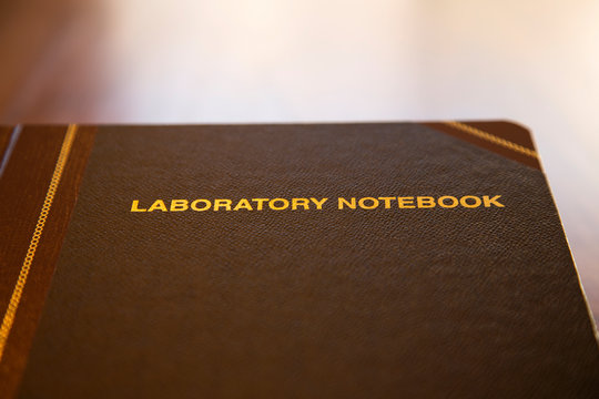 Data and research laboratory notebook on wood table with copy space available