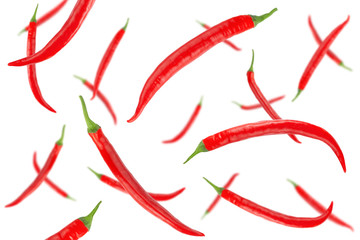 Falling red hot chilli peppers isolated on a white background with clipping path. Flying vegetables. Top view.