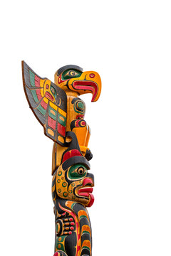 Colourful wooden carved Canadian totem pole against white background
