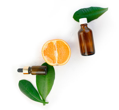 Aromatherapy and heathcare composition with orange essential oil bottle, fresh citrus and leaves on white background. Spa, natural cosmetic concept. Detox, anti-cellulite effect. Top view.