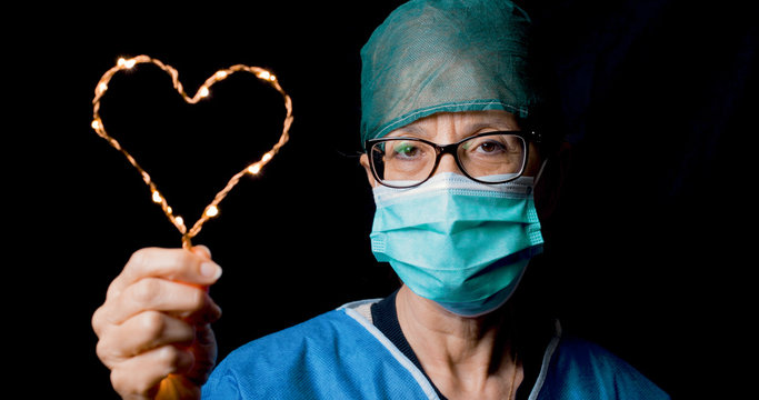 Medico donna che tiene il cuore per dare speranza ai malati di coronavirus