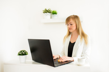 Remote work.Entrepreneur woman wearing white jacket working with a laptop sitting on a couch at home.Online consultation of a tax lawyer, accountant in the office