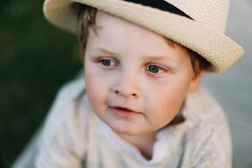 Closeup portrait of a smiling boy outdoors. A beautiful cute boy in a hat