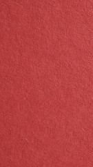 The surface of dark red cardboard. Rough paper texture with cellulose fibers. Saturated color. Vertical background or wallpaper for phone or mobile. Macro