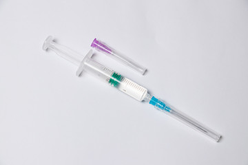 Parts of medical syringe isolated on white background. Needle, syringe barrel with plunger, dosage...