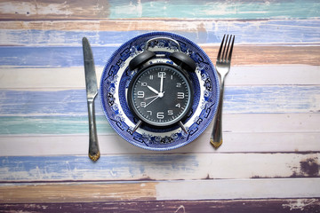 the concept of Healthy Food, alarm clock on plate 