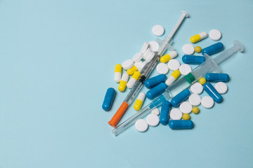 Medical syringe and pills on a dark blue background, health and vaccination concept.