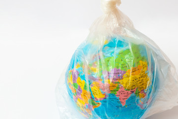 World Environment Day concept.Toy world globe in white plastic bag on white background.