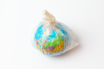 World Environment Day concept.Toy world globe in white plastic bag on white background.