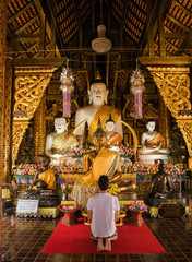 Man prays inside a buddhist temple in the city of Chiang Mai, Thailand