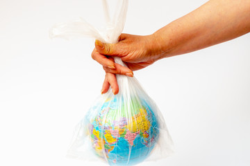  Image of human hand holds the planet earth in a white plastic bag over white background
