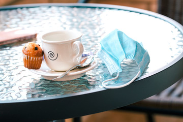 New normality. Cafe on the terrace of a bar with a mask on the table.
