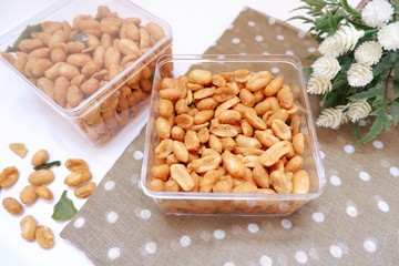 close up of kacang telur or egg peanut in a box with polkadot fabric with blurry background. Indonesian typical homemade crispy fried snack. Made from flour, egg, nut, onion and lime leaf. Salty taste