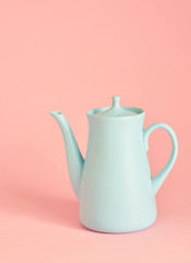minimalism concept with light pastel colored blue teapot on pink background.  Flat lay. Tea time concept. Empty space
