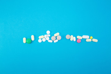 Heap of colorful pills on blue background