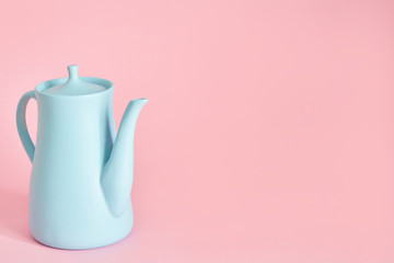 minimalism concept with light pastel colored blue teapot on pink background.  Flat lay. Tea time concept. Empty space
