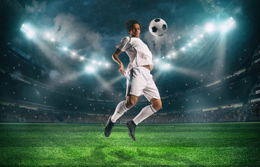 Naklejka premium Soccer striker stops the ball with an acrobatic jump at the stadium during a night match