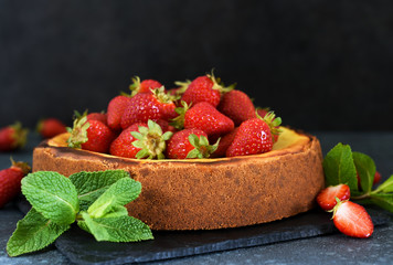 Beautiful cheesecake with strawberries on a dark background with a place for texts. Food advertisement.
