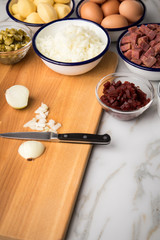 Zutaten  für Norddeutscher Hamburger Labskaus mit Rindfleisch Corned Beef, Rote Beete, Kartoffeln, Saure Gurken, Zwiebeln, Ei und Rollmops auf Marmor Arbeitsfläche