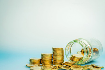 Gold coin vertically aligned in the growth direction and money in a glass jar, saving money on future spending concept.