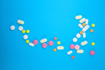 scattering of medical colorful pills on blue background