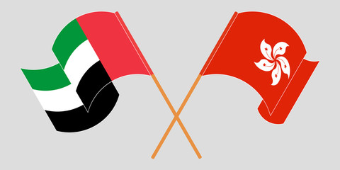 Crossed and waving flags of Hong Kong and the United Arab Emirates