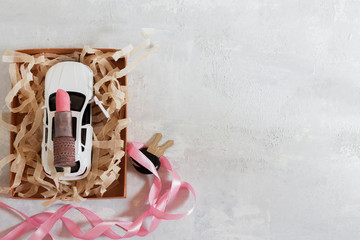 White car and car keys in a gift box on a light background. Gift to beloved woman, daughter, mom.