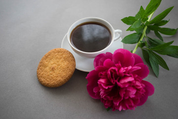 breakfast with coffee and cookies with peony on a gray background