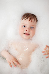 Baby in bath tub bathroom with soap swim in water
