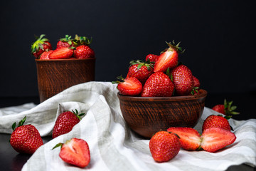 Fresh strawberries in ceramic bowl on dark background