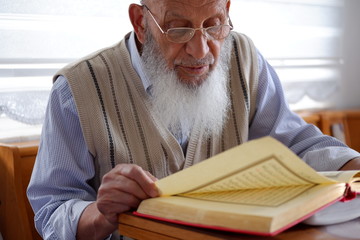 Close-up of an Elderly Muslim Turkish Man's face who is reading Holy Quran during Ramadan....
