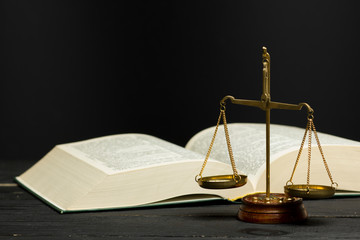 Law concept - Open law book with a wooden judges gavel on table in a courtroom or law enforcement office isolated on white background. Copy space for text