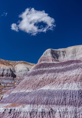 Colorful hills and mountain with blue sky and white clouds.