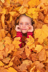 girl face peeks out of leaves