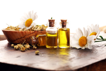 Chamomile Composition with essential oil and chamomile flowers on wooden rustic table