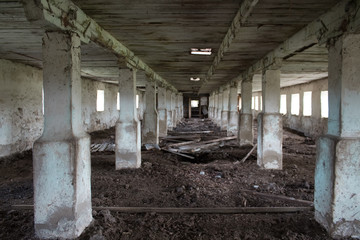 Fototapeta na wymiar Abandoned building with columns. Industrial building. Factory abandoned, old factory interior. Gloomy building