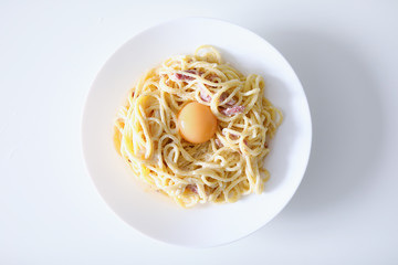Carbonara pasta with egg yolk and bacon closeup background