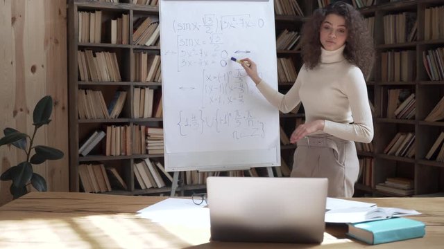 Young hispanic female math school teacher remote tutor giving online class lesson teaching by laptop computer webcam webinar zoom pc app video conference call tutorial course explain distance lecture.