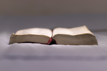 Selective focus of an open Bible placed on a bed