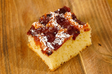 One piece of cherry pie lies on a wooden surface