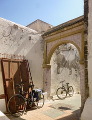 Bikes leaning against wall next to arch